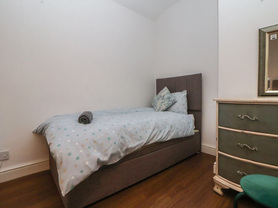 A bedroom with a bed a drawer unit and a mirror at Ravenswood Penthouse Chester