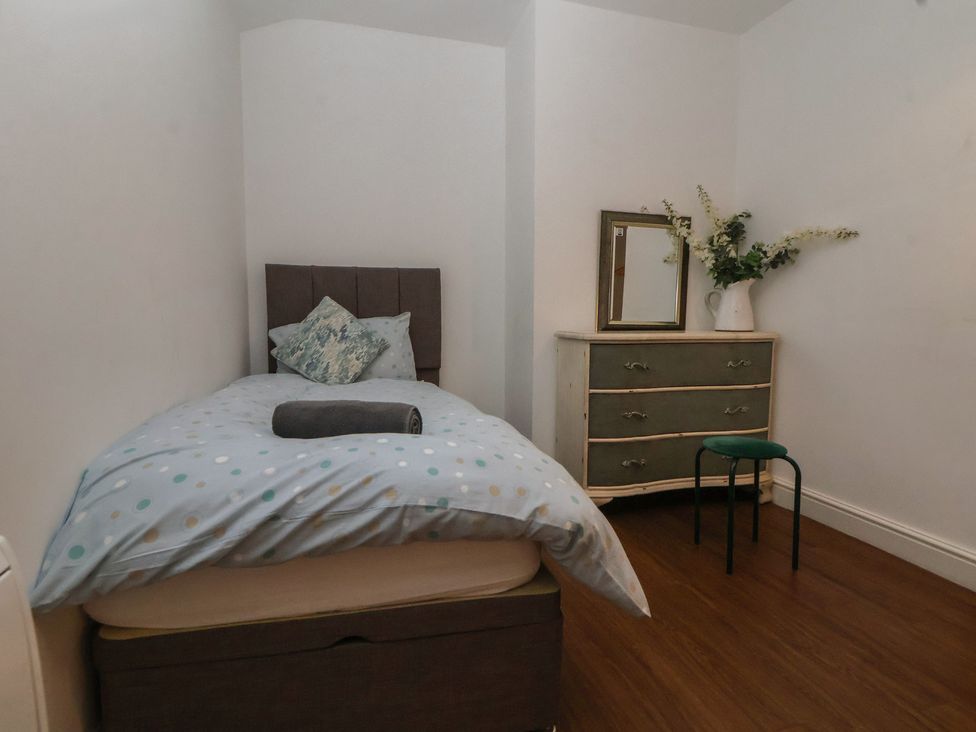 A bedroom with a bed, dresser, mirror and chair at Ravenswood Penthouse in Chester