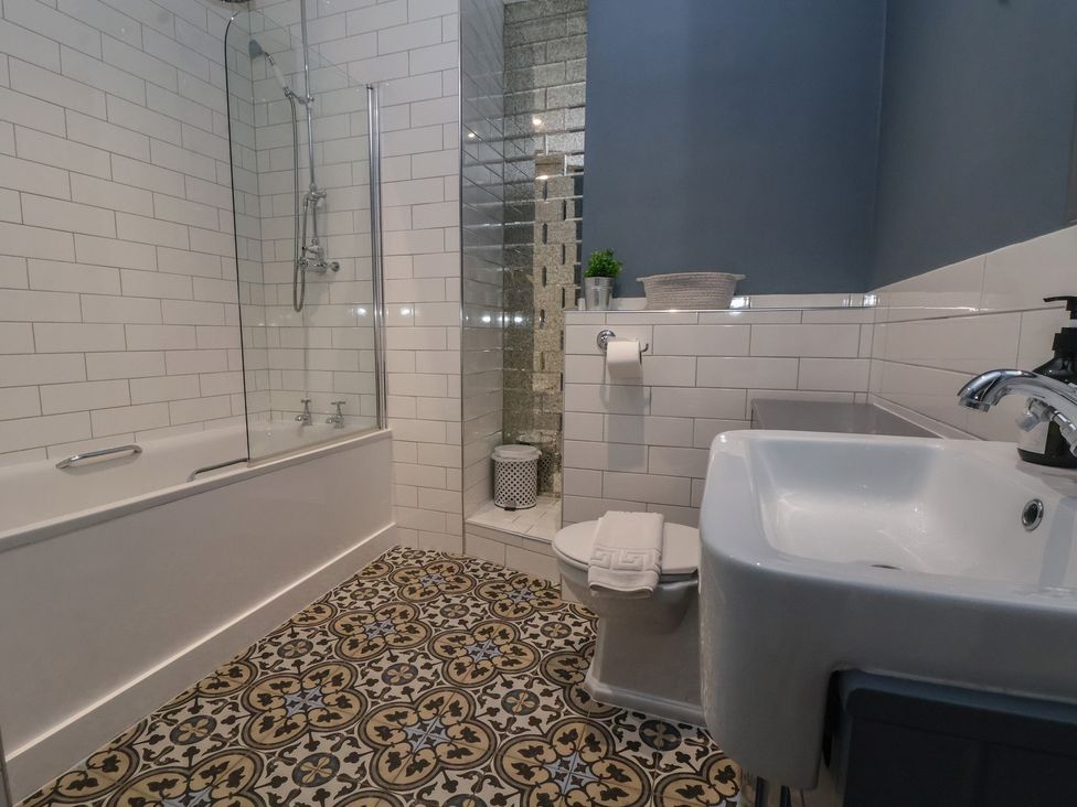 A bathroom with a bathtub, shower, sink, and toilet at Ravenswood Penthouse in Chester
