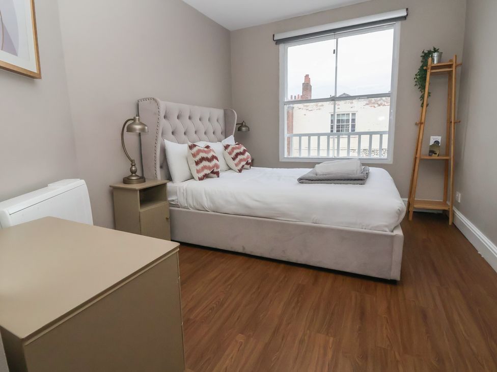 A bedroom with a bed and a window at Ravenswood Penthouse in Chester