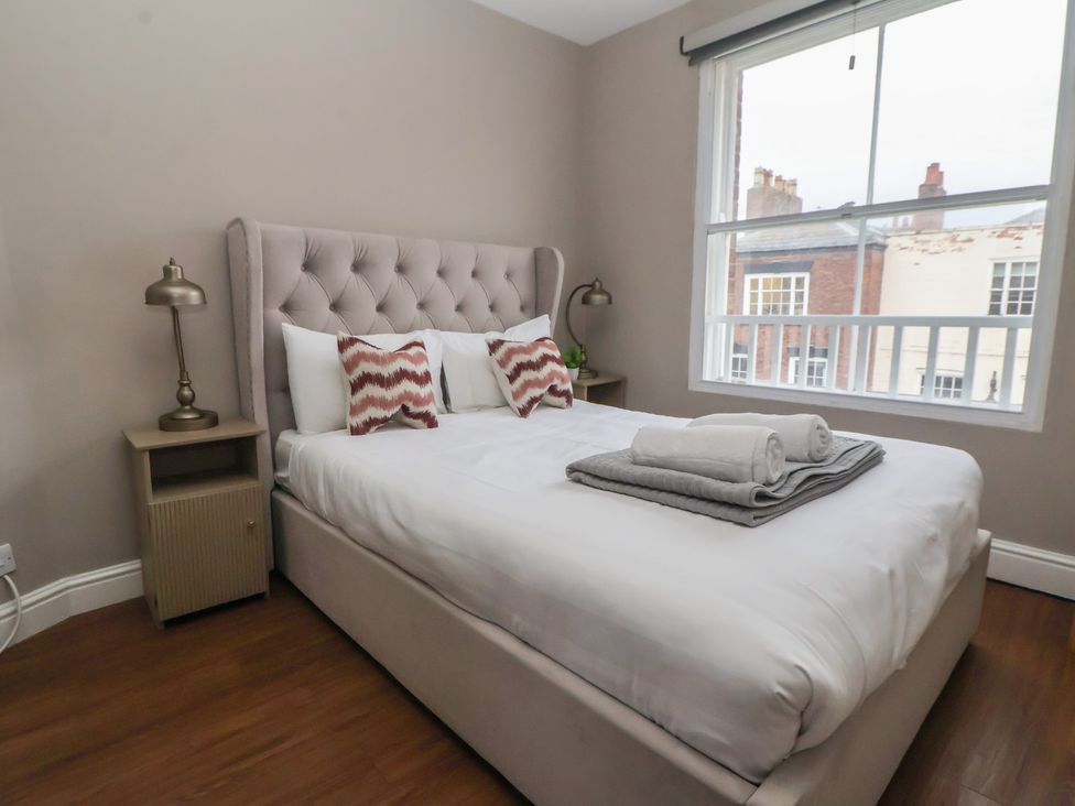 A bedroom with a bed and bedside lamp at Ravenswood Penthouse in Chester