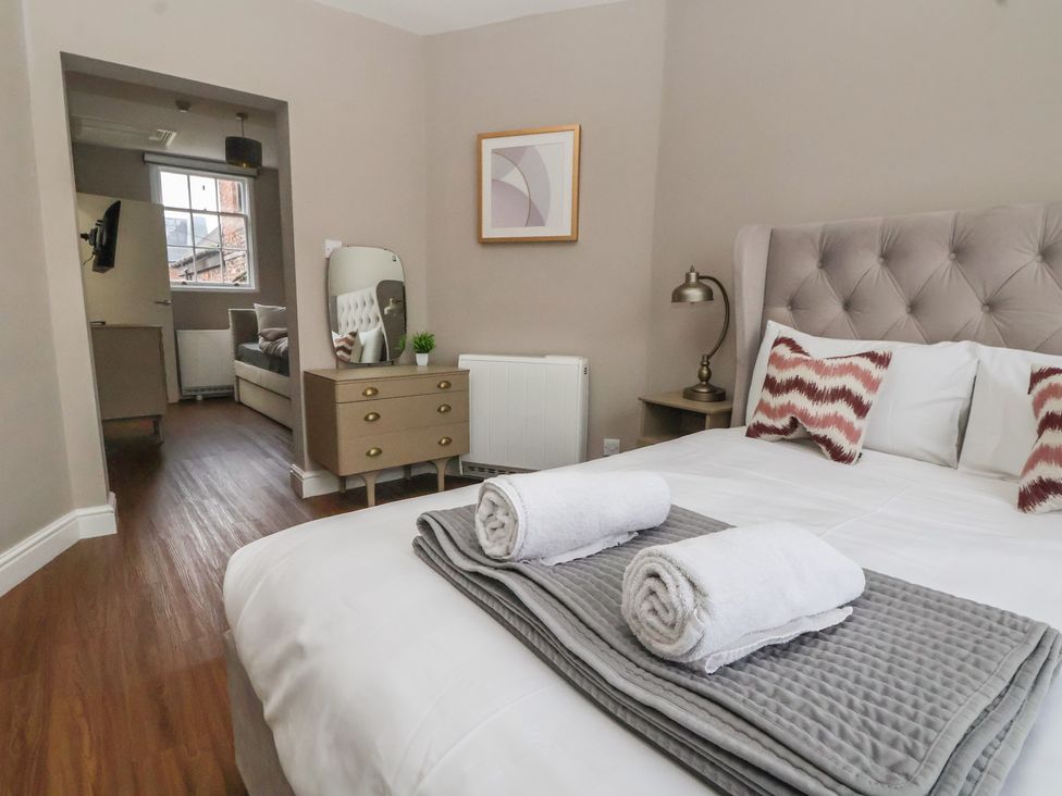A bedroom with a bed and towels at Ravenswood Penthouse in Chester