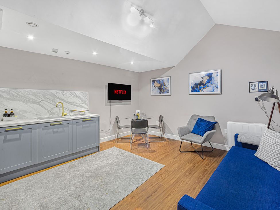 A living room with a kitchenette and television at Kingsley Loft in Chester
