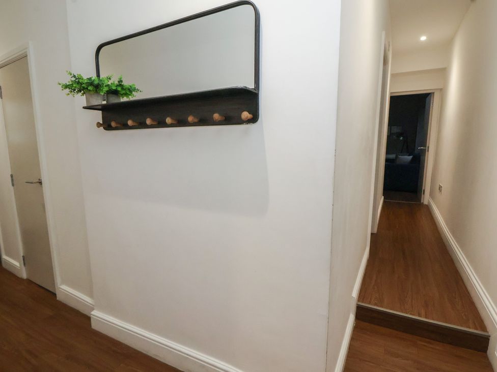 A hallway with a shelf and mirror at Kingsley Loft in Chester