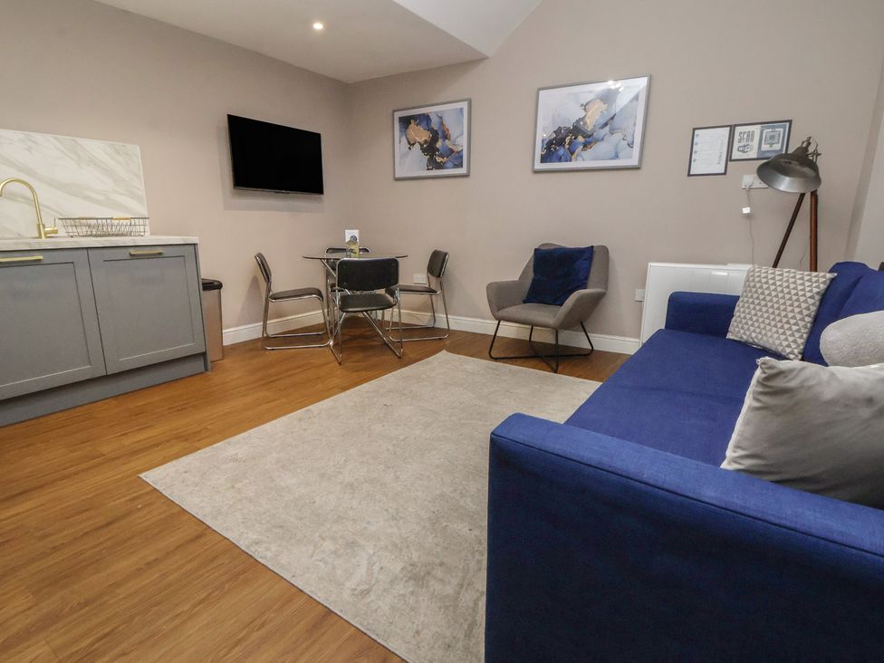 A living room with a sofa and a dining table at Kingsley Loft Chester