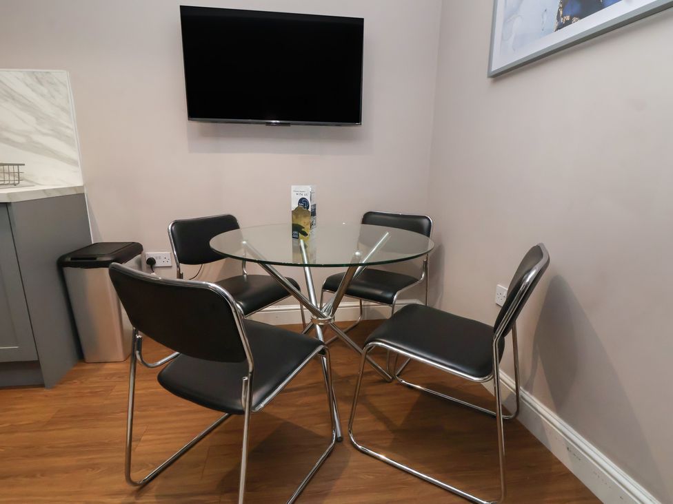 A dining room with a glass table and chairs at Kingsley Loft Chester