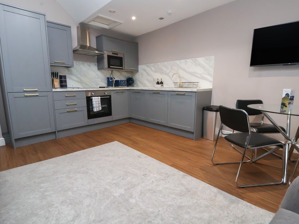 A kitchen with cabinets, sink and table at Kingsley Loft Chester