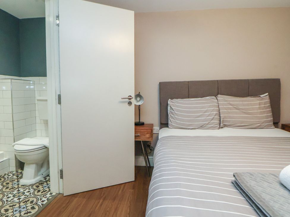 A bedroom with a bed and a bathroom door at Kingsley Loft Chester