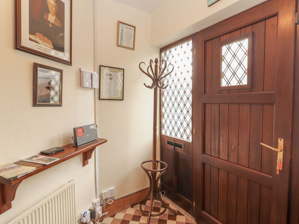 A hallway with a coat rack and a door at Coole Gate Lodge, Gort, County Galway