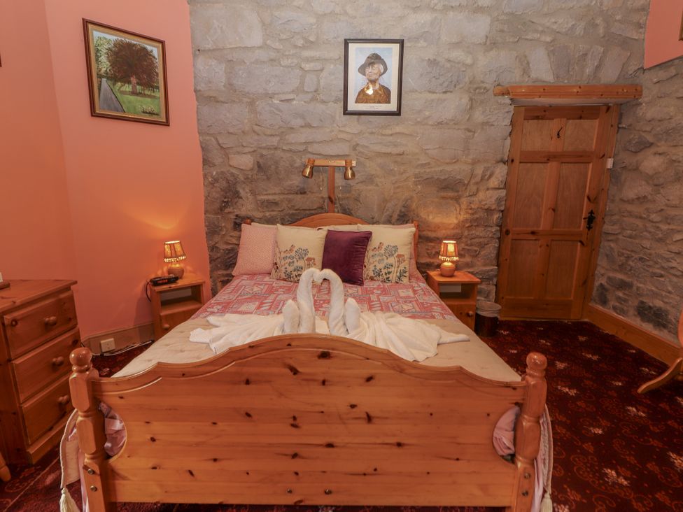 A bedroom with a double bed and nightstand at Coole Gate Lodge in Gort, County Galway