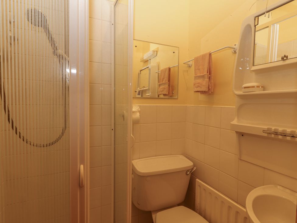 A bathroom with a shower, toilet, and sink at Coole Gate Lodge, Gort, County Galway