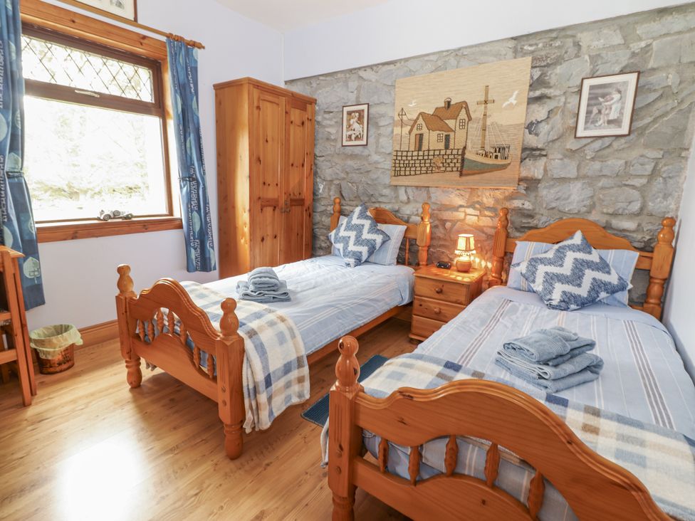 A bedroom with two single beds and a bedside table at Coole Gate Lodge, Gort, County Galway