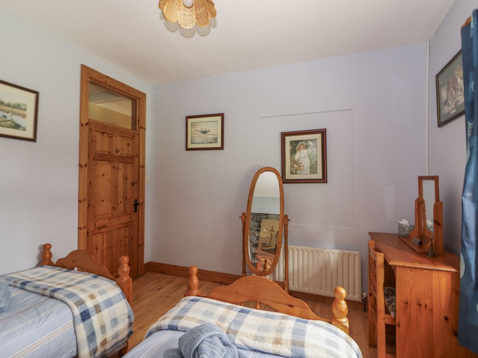 A bedroom with two beds and a mirror at Coole Gate Lodge in Gort, County Galway