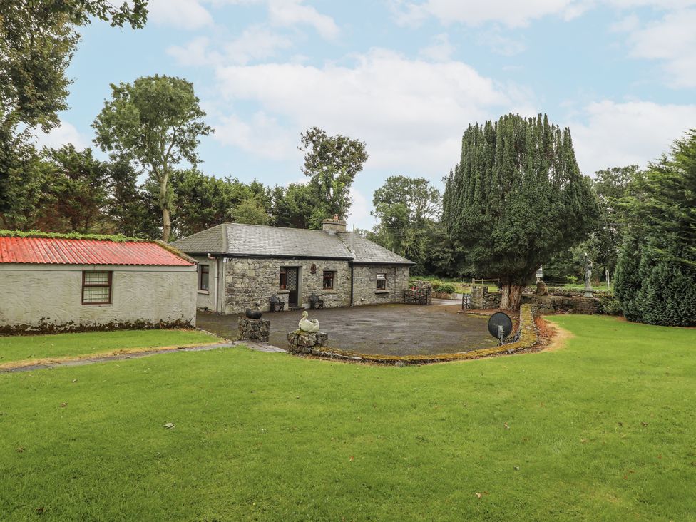 A house with trees and a patio at Coole Gate Lodge, Gort, County Galway