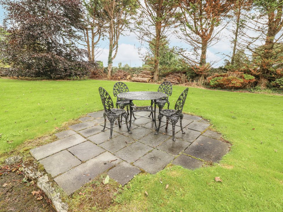 A garden with a table and chairs on a paved area at Coole Gate Lodge, Gort, County Galway