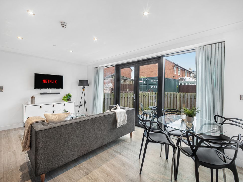 A living room with a sofa and TV at Eastgate Suite Chester
