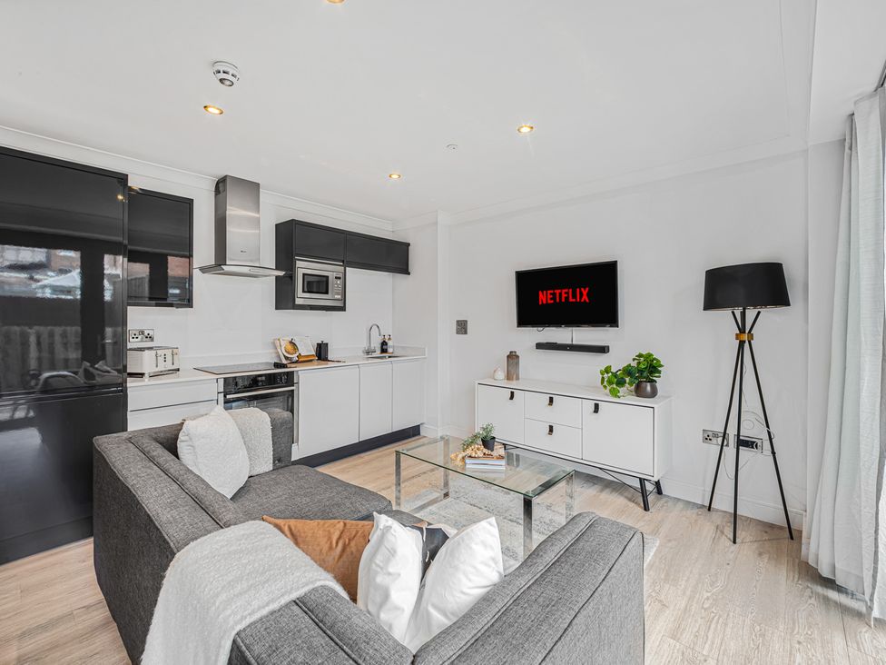 A living room with a sofa and TV display at Eastgate Suite in Chester