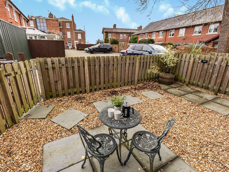 A garden with a table and chairs surrounded by gravel at Eastgate Suite in Chester