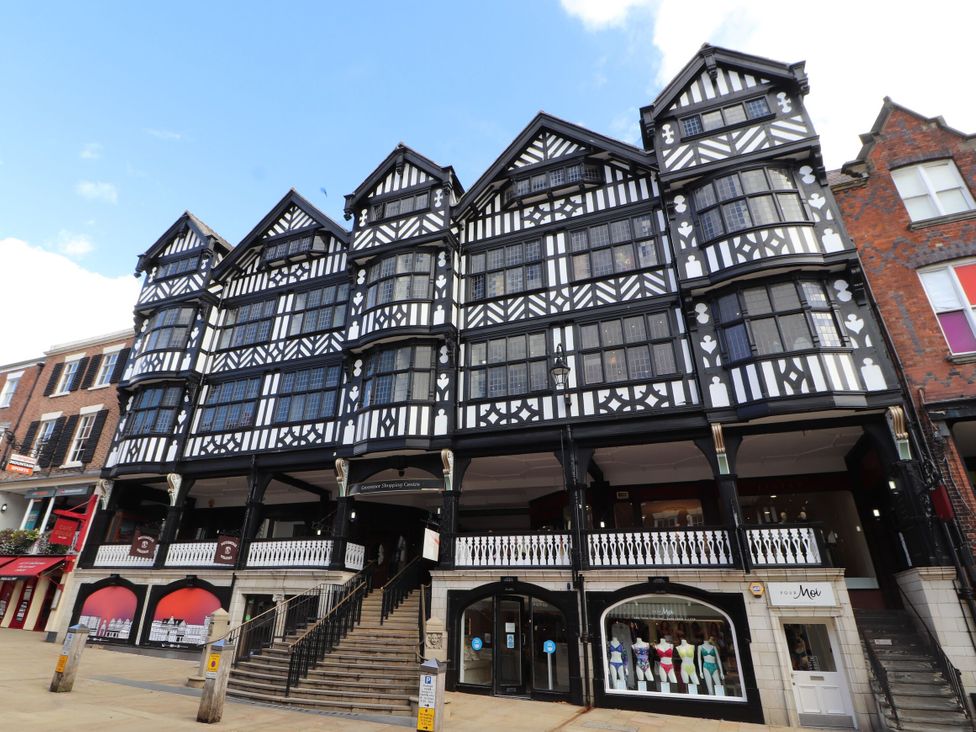 An exterior view of a historic building with multiple windows and stairs at Eastgate Suite Chester