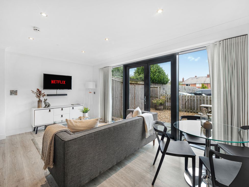 A living room with a TV and dining table at Newland Suite Chester