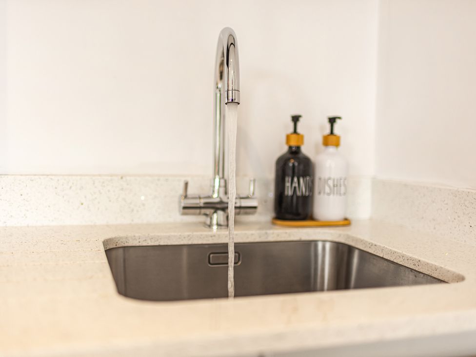 A sink with a faucet and soap dispensers at Newland Suite in Chester