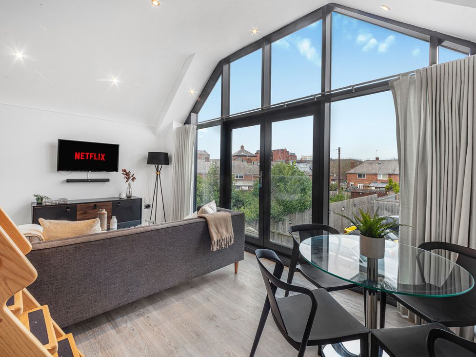 A living room with a sofa and a television at Mulberry Apartment in Chester