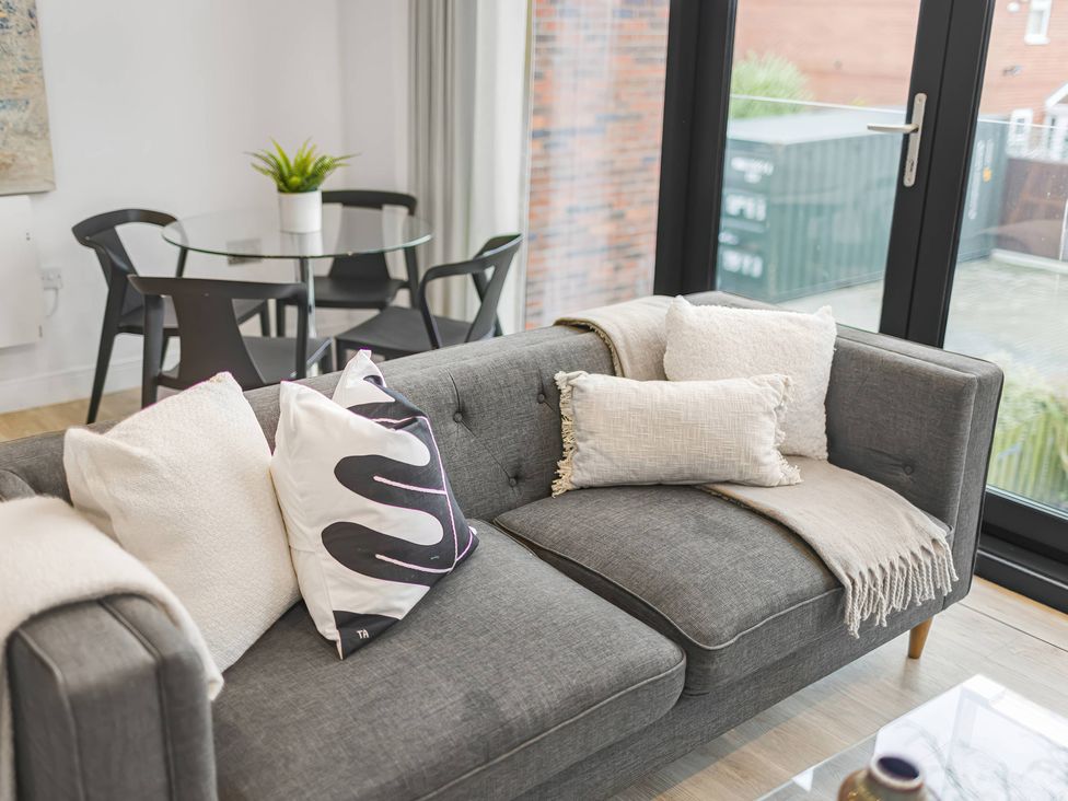 A living room with a sofa and dining table at Grosvenor Apartment in Chester