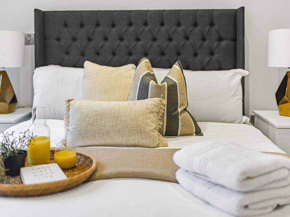 A bedroom with a bed and decorative pillows at Grosvenor Apartment in Chester