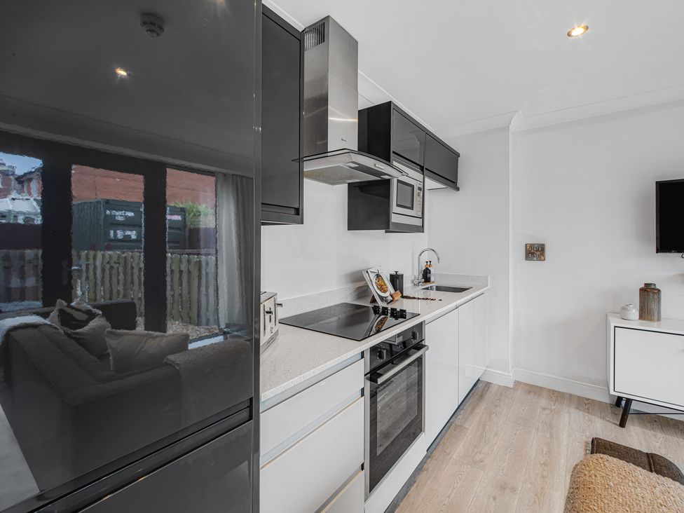 A kitchen with appliances and furniture at York Suite in Chester