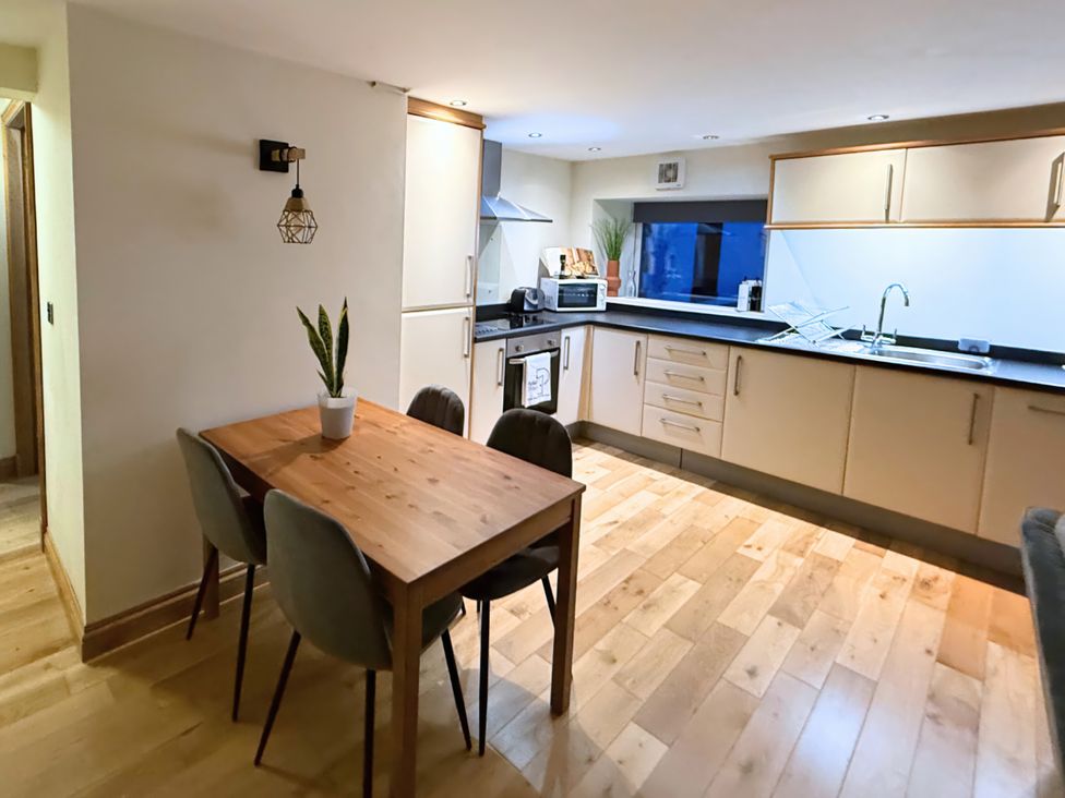 A kitchen with a dining table and chairs at The Stables in Troutbeck