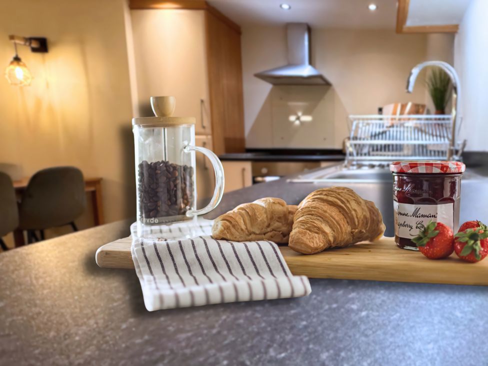 Coffee jar and croissant on a kitchen counter at The Stables in Troutbeck