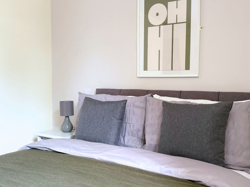 A bedroom with a bed and a bedside table at The Stables in Troutbeck