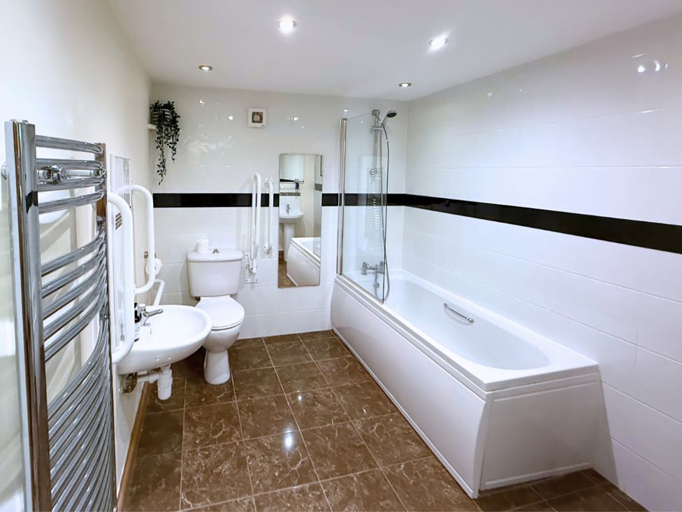 A bathroom with a bathtub and shower at The Stables in Troutbeck
