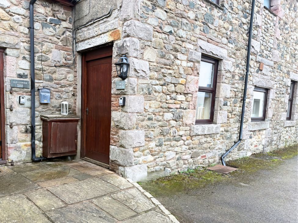 An entrance with a door and stone wall at The Stables in Troutbeck
