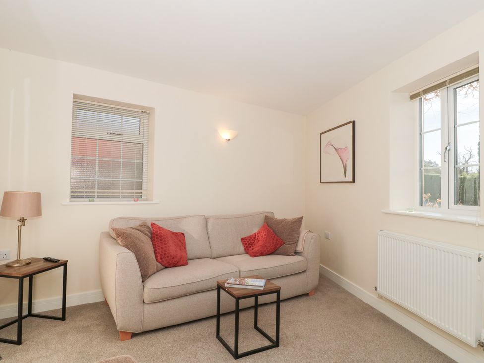 A living room with a sofa and coffee table at Wellinghill Cottage at Wellinghill House Charlton Kings