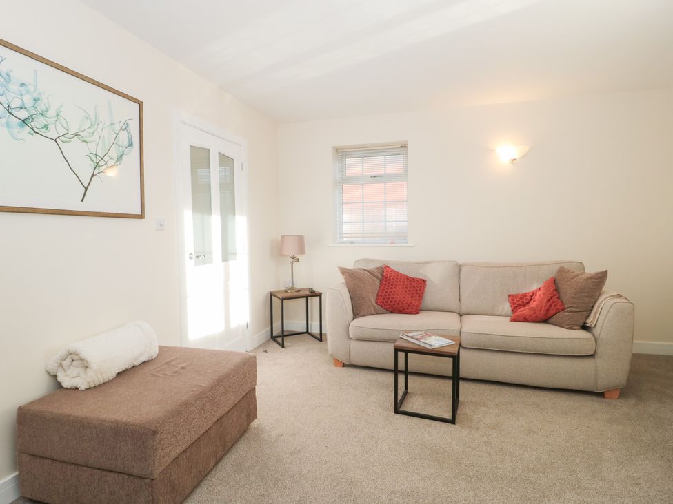 A living room with a sofa and coffee table at Wellinghill Cottage at Wellinghill House Charlton Kings
