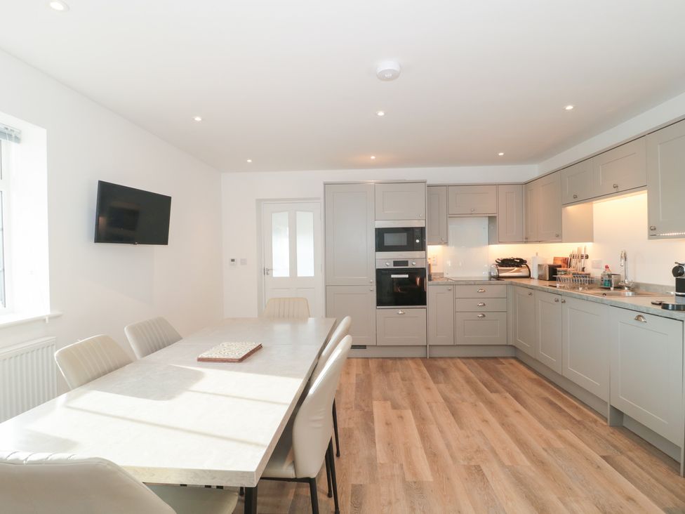 A kitchen with a dining table and chairs at Wellinghill Cottage at Wellinghill House Charlton Kings