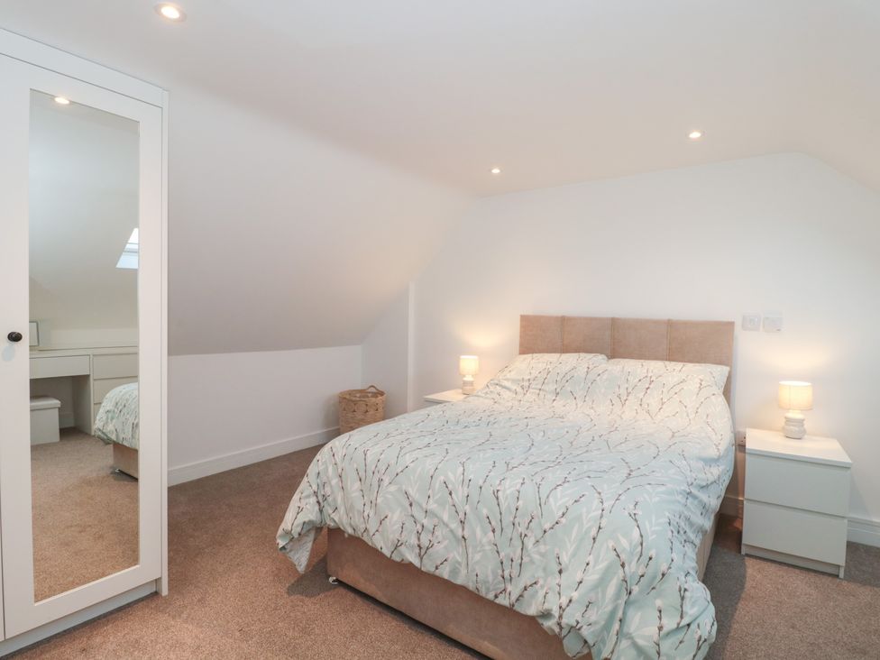 A bedroom with a bed and nightstands at Wellinghill Cottage at Wellinghill House Charlton Kings