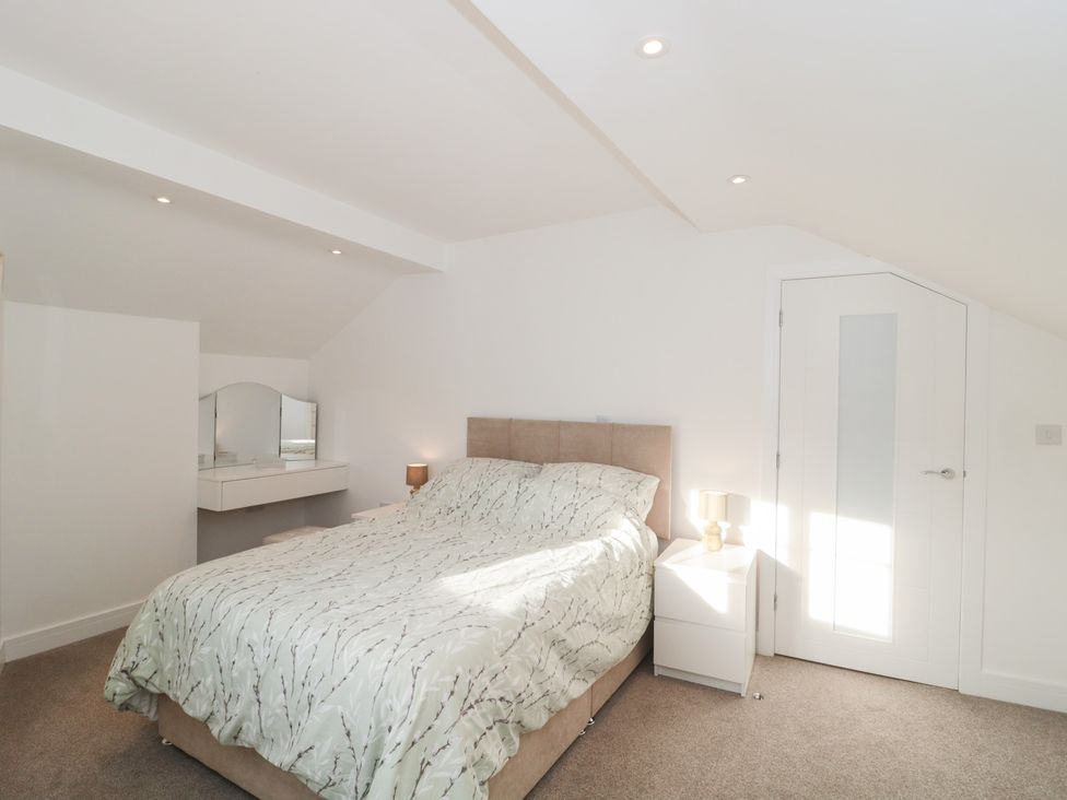 A bedroom with a bed and bedside table at Wellinghill Cottage at Wellinghill House Charlton Kings