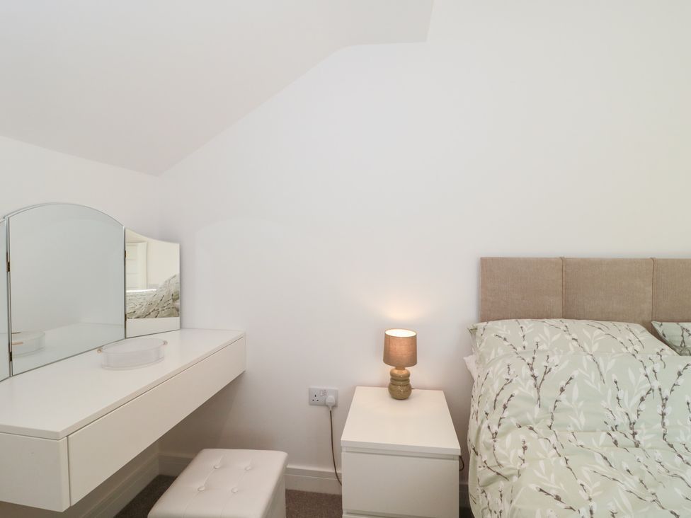 A bedroom with a bed and vanity table at Wellinghill Cottage at Wellinghill House Charlton Kings