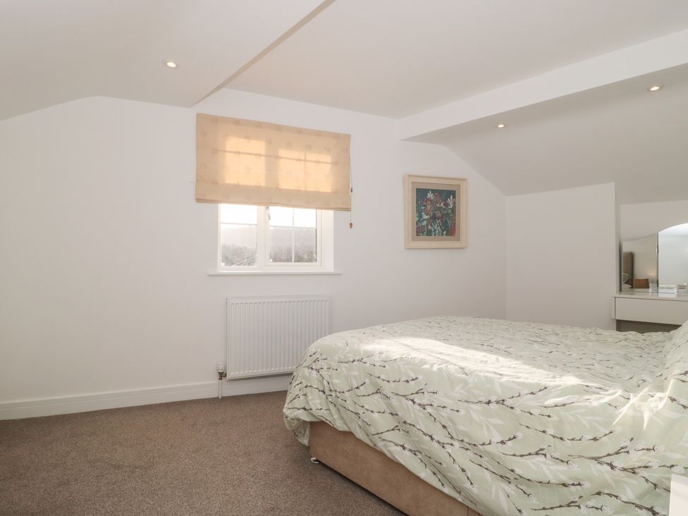 A bedroom with a bed and a window at Wellinghill Cottage at Wellinghill House Charlton Kings