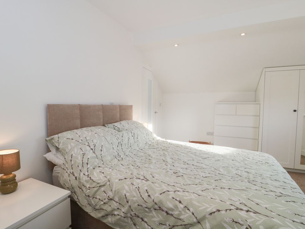 A bedroom with a bed and wardrobe at Wellinghill Cottage at Wellinghill House, Charlton Kings