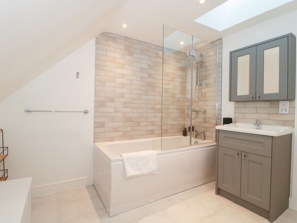 A bathroom with a shower and bathtub at Wellinghill Cottage at Wellinghill House, Charlton Kings