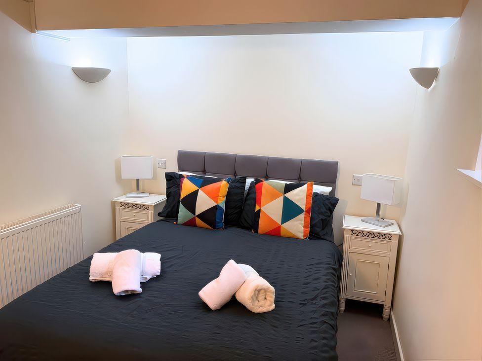 A bedroom with a bed and bedside tables at Old Corner Barn Troutbeck