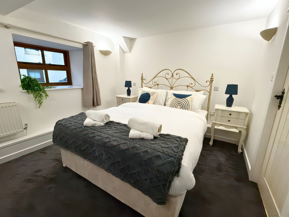 A bedroom with a bed and nightstands at The Old Corner Barn in Troutbeck