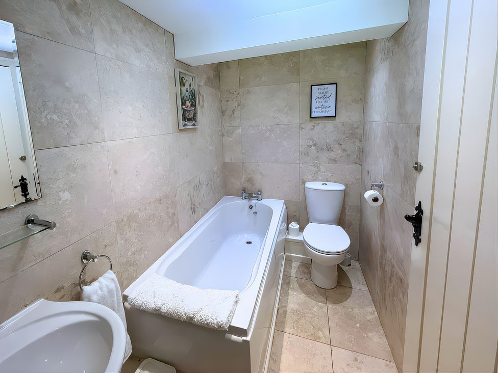 A bathroom with a bathtub and toilet at Old Corner Barn in Troutbeck