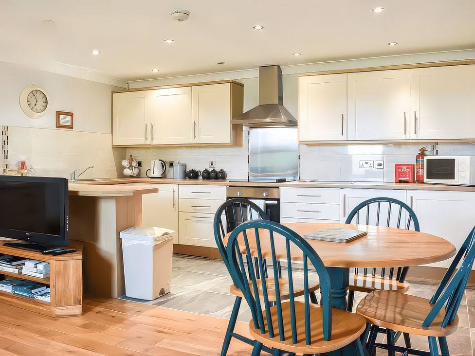 A kitchen with appliances and a dining table at Crag Barn Cottage in Troutbeck