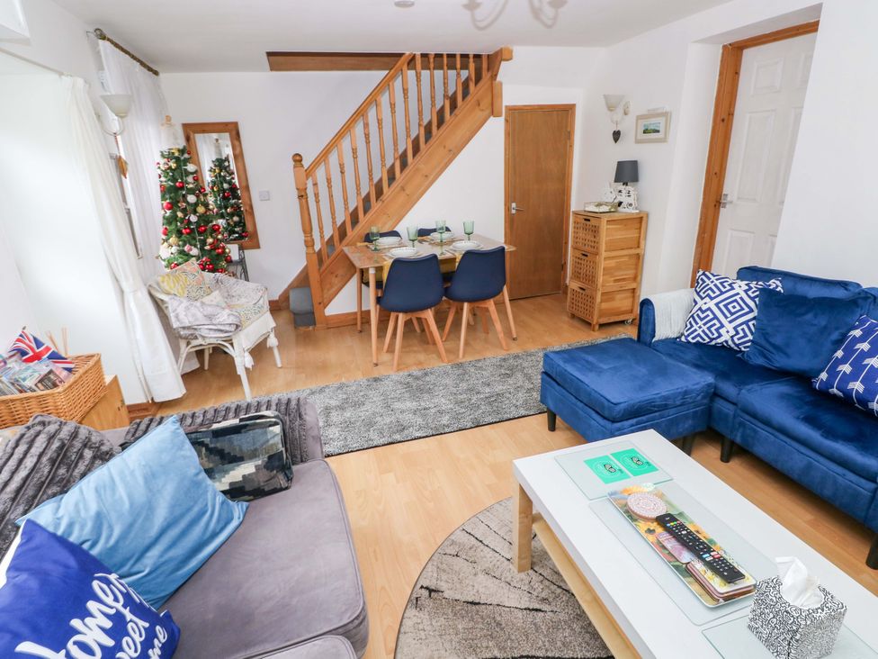 A living room with a dining area and Christmas tree at Tawe Cottage in Swansea