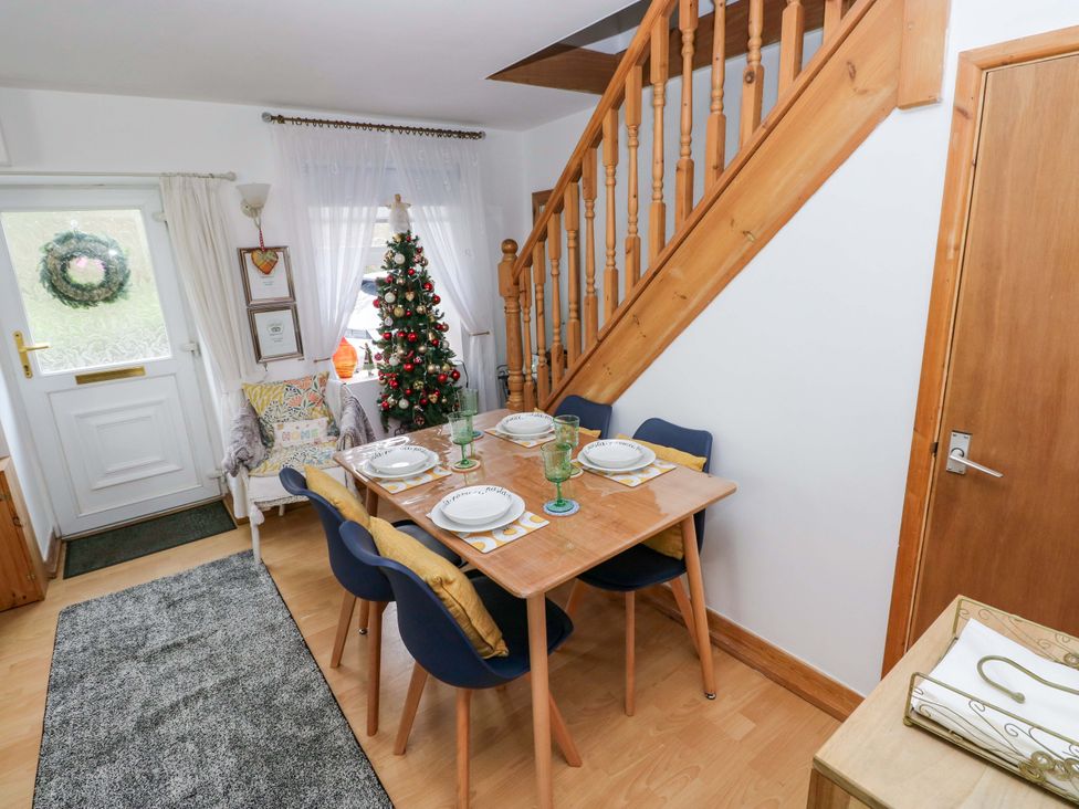 A dining room with a table set and a Christmas tree at Tawe Cottage Swansea