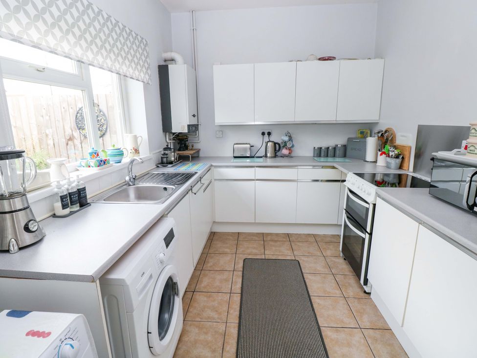 A kitchen with appliances and cabinets at Tawe Cottage in Swansea